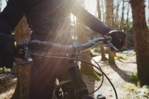 Midsection of mountain biker riding in woodland — Stock Photo