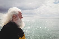 Вид збоку Продуманий рибалка стоїть на рибальському човні — стокове фото