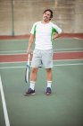 Joueur de tennis fatigué debout sur le terrain de sport avec raquette — Photo de stock