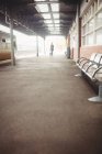 Vista distante della donna in piedi sulla piattaforma della stazione ferroviaria — Foto stock