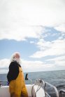 Вдумливий рибалка дивиться на море з рибальського човна — стокове фото