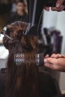 Вид ззаду жінка сушить волосся з фену в перукарні — стокове фото