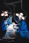 Cirurgiões que realizam operação em sala de operação no hospital — Fotografia de Stock