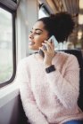 Щаслива жінка розмовляє по телефону, сидячи в потязі — стокове фото