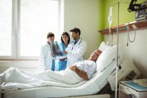 Лікарі взаємодіючих над рентгенівського звіт з хворого на пацієнта у лікарні — стокове фото