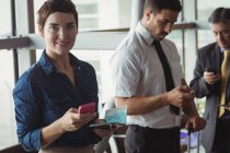 Geschäftsleute mit Mobiltelefonen im Wartebereich am Flughafen-Terminal — Stockfoto