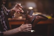 Mãos de sapateiro reparando um sapato na oficina — Fotografia de Stock