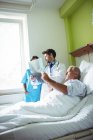 Лікар і медсестра, що взаємодіють через рентгенівський звіт з пацієнтом у лікарні — стокове фото