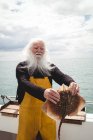 Retrato del pescador sosteniendo peces rayas en barco - foto de stock