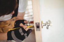 Carpenter fixing door lock at home — Stock Photo