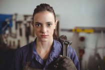 Female welder holding wrench tool in workshop — Stock Photo