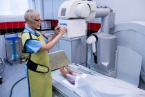 Doctor using x-ray machine to examining patient in hospital — Stock Photo