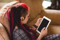 Donna hipster con tablet digitale sul divano di casa — Foto stock