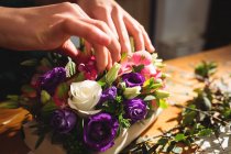 Nahaufnahme einer Floristin bei der Vorbereitung eines Blumenstraußes in ihrem Blumenladen — Stockfoto