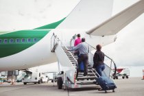 Passagiere steigen auf die Treppe und steigen am Flughafen in das Flugzeug ein — Stockfoto