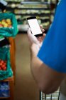 Cropped image of Man using mobile phone while shopping in supermarket — Stock Photo