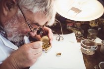 Horólogo reparando un reloj de bolsillo en el taller - foto de stock
