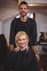 Портрет улыбающегося парикмахера и клиента в салоне — стоковое фото