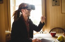 Joven feliz usando simulador de realidad virtual en casa - foto de stock
