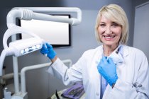 Portrait of smiling dentist at dental clinic — Stock Photo