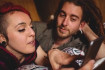 Junges Hipster-Paar benutzt Handy im heimischen Bett — Stockfoto