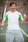 Glückliche Tennisspielerin posiert nach Sieg auf Court — Stockfoto