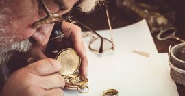 Горолог ремонтує кишеньковий годинник у майстерні — стокове фото