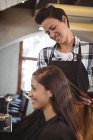 Усміхнене жіночий перукар, працюють на клієнта в перукарні — стокове фото