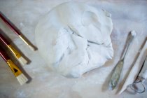 Close-up de argila de moldagem e ferramentas na bancada em oficina de cerâmica — Fotografia de Stock