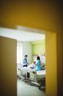 Врач и медсестра взаимодействуют с пациентом в больнице — стоковое фото