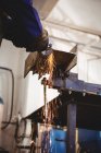Обрезанное изображение металла для распиловки сварщика с помощью электрического инструмента в цехе — стоковое фото