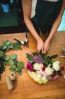 Обрезанный образ флористки, готовящей букет цветов в цветочном магазине — стоковое фото