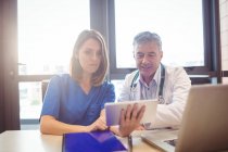 Médico discutindo com enfermeira sobre tablet digital no hospital — Fotografia de Stock