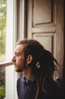 Close-up of contemplated hipster by window at home — Stock Photo