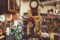 Old horologists workshop with clock repairing tools, equipment and clocks on the wall — Stock Photo