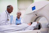 Doctors interacting with patient in scanning room at hospital — Stock Photo