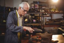 Cordonnier réparer une chaussure en atelier — Photo de stock