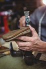 Nahaufnahme des Schuhmachers, der in der Werkstatt auf einen Schuh hämmert — Stockfoto