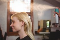 Cabeleireiro clientes styling cabelo com spray no salão — Fotografia de Stock