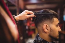 El hombre que se corta el pelo en la peluquería - foto de stock