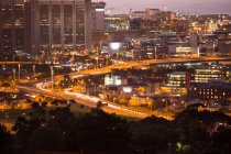 Escena urbana de paisaje urbano iluminado en la noche - foto de stock