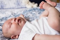 Baby sleeping on bed in bedroom at home — Stock Photo