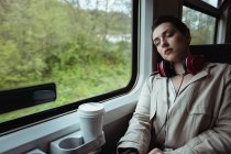 Jeune femme dormant par la fenêtre dans le train — Photo de stock