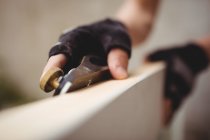 Imagem cortada de carpinteiro nivelamento moldura de madeira com plano de bloco — Fotografia de Stock