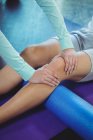Обрізане зображення фізіотерапевта, що дає фізичну терапію коліну пацієнта чоловічої статі в клініці — стокове фото