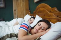 Couple sleeping together on bed at bedroom — Stock Photo