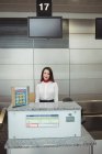 Portrait of airline check-in attendant at airport check-in counter — Stock Photo