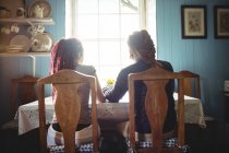 Rückansicht eines Paares, das zu Hause am Tisch sitzt — Stockfoto