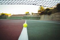 Balle de tennis sur la ligne centrale du court de tennis — Photo de stock