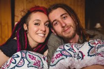 Портрет усміхненої молодої пари, що розслабляється на ліжку вдома — стокове фото